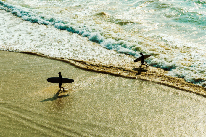 2 surfeurs marchent dans la mer